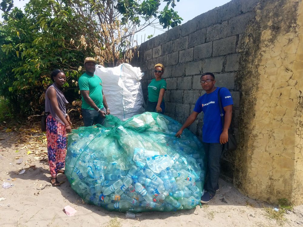 Caption: A photo of Emeka holding a large bag of plastic bottles together with three other people. (Courtesy of Local Guide @EmekaUlor)