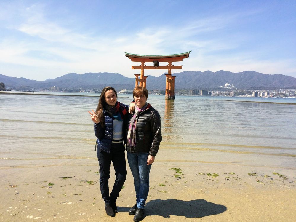 Caption: A photo of me and my mom in front of the tall red Itsukushima Floating Torii Gate in Japan. (Local Guide @Ivi_Ge)