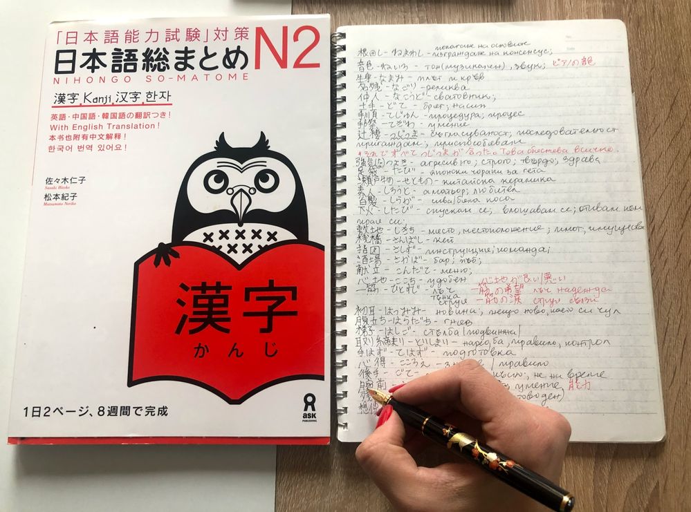 Caption: A photo of a Japanese textbook and a notebook with a list of Japanese characters. (Local Guide @Ivi_Ge)