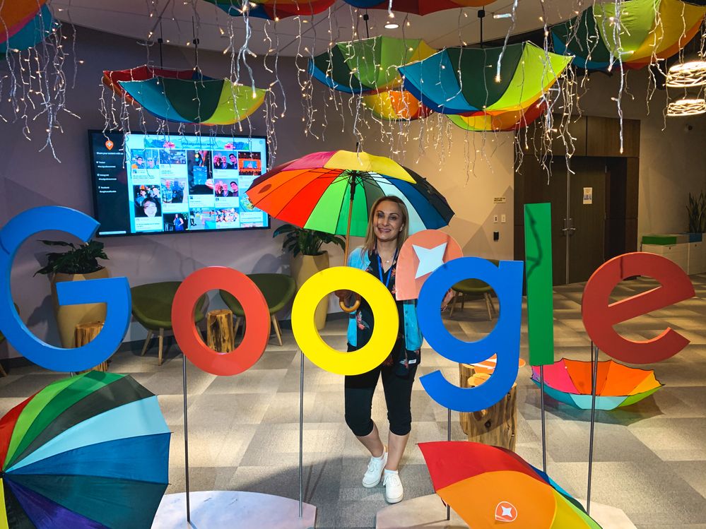 Caption: A photo of Penny holding a colorful umbrella and standing behind a Google sign at Connect Live 2019. (Courtesy of Local Guide @PennyChristie)