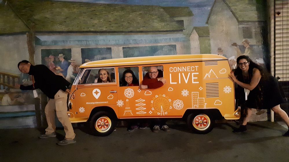 Caption: A photo of Megan and fellow Local Guides playing around with an orange cutout van during a Connect Live event. (Courtesy of Local Guide @Kwiksatik)