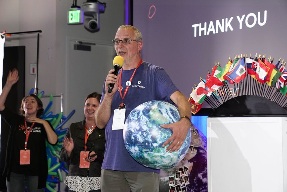 Caption: A photo of Ermes holding a model of the Earth and giving a speech during Connect Live 2018.