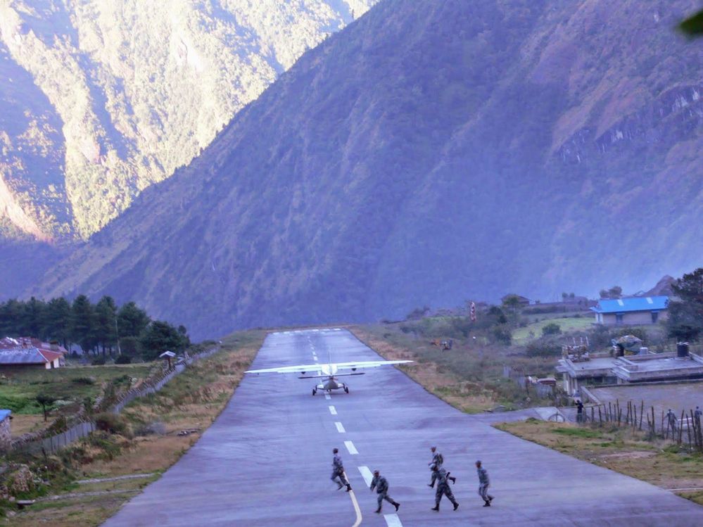 Caption: A photo of a plane landing at Tenzing-Hillary Airport and people running from the runway. (Local Guide @AdamGT)