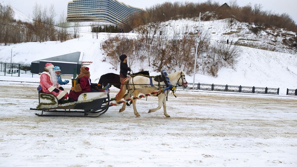 Caption: A photo of a horse-drawn sleigh with a Santa Claus, a Snow Maiden, and a musician seated inside it in Ufa, Russia. (Local Guide @Emmik20)