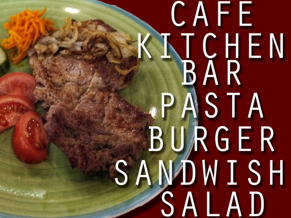 Caption:  A steak with slice tomatoes and words written on the glass wall inside the cafe.