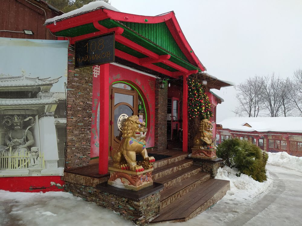 Caption:  A red-green Chinese doorway with two golden imperial guardian lions.