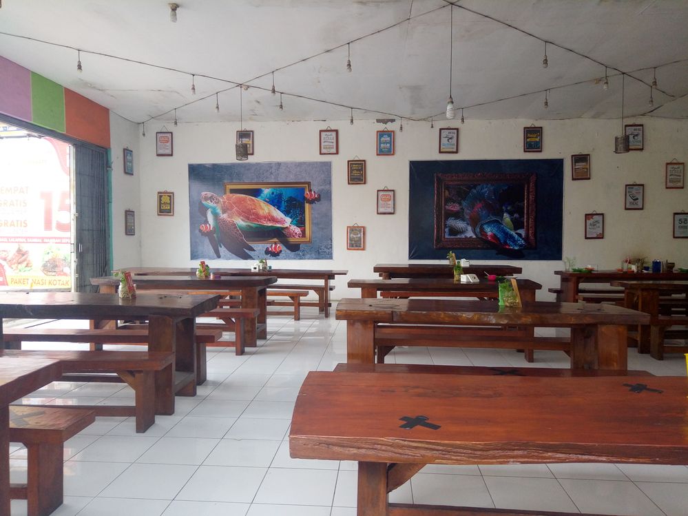 Caption: A photo inside Ayam Bakar Pak D - Cemengkalang, a food place in Sidoarjo, East Java, showing the space, tables, and decoration. (Local Guide @putrisetyo)