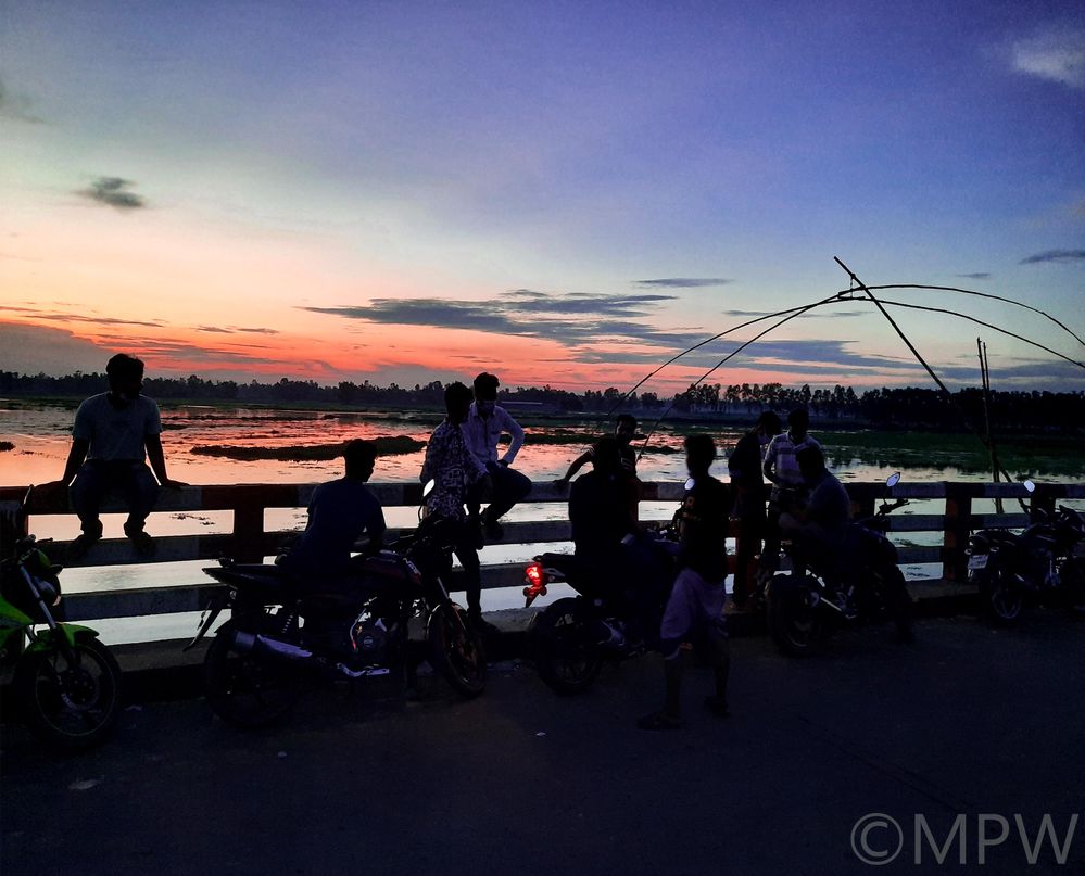 Caption: A photo of a group of friends wearing masks and enjoying the sunset from Monpura Bridge in Chapri, Bangladesh. (Local Guide @MukulR)
