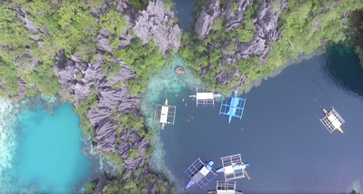 Rugged limestone cliffs & boats shot from a drone