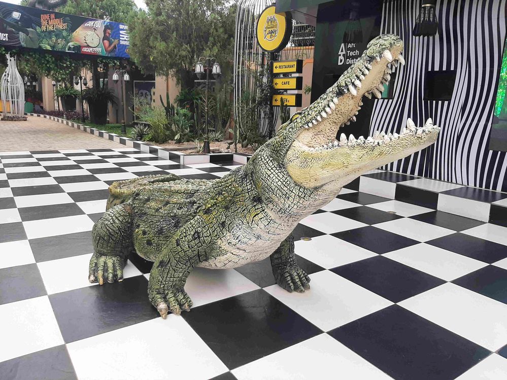 Caption: A photo of a crocodile sculpture on black and white tiles at the entrance to the Digital Museum in Abuja, Nigeria. (Local Guide @Shola4sure)