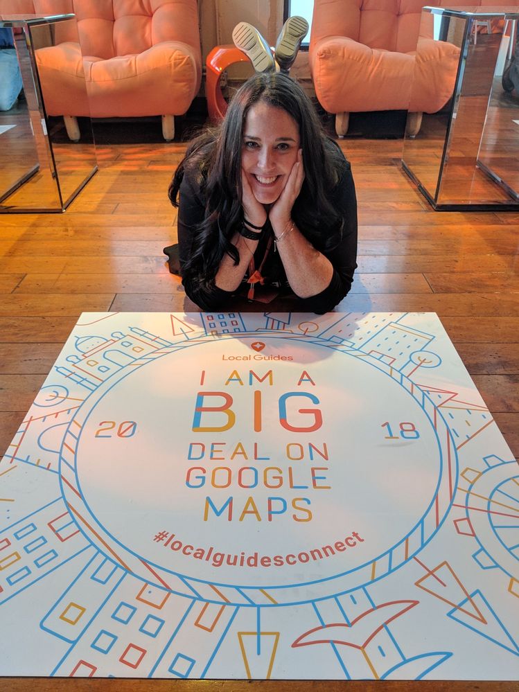 Caption: A photo of Traci on the floor next to a decal that says "I am a big deal on Google Maps."