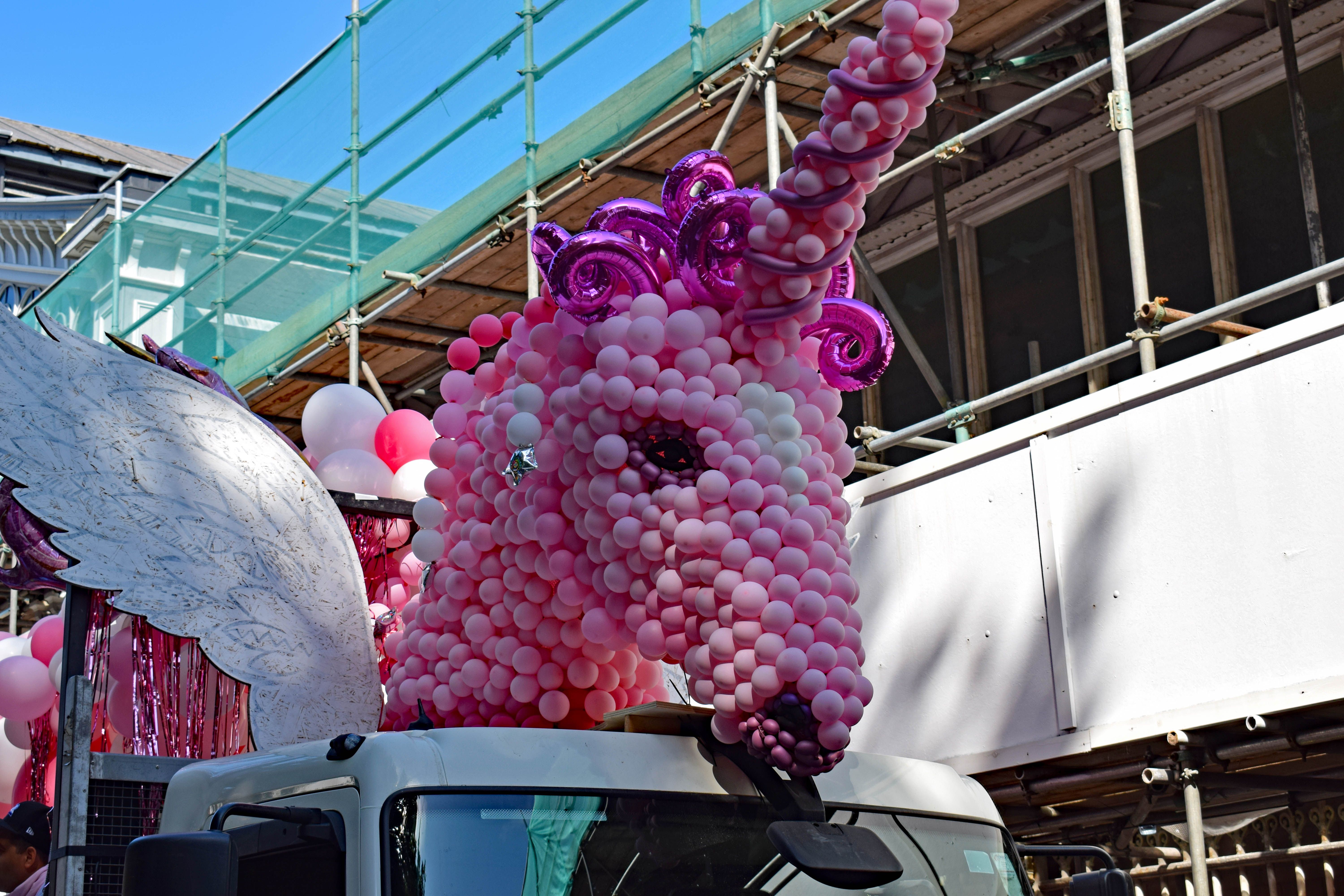 A pink unicorn float waiting to join the parade, The unicorn is made from pink balloons