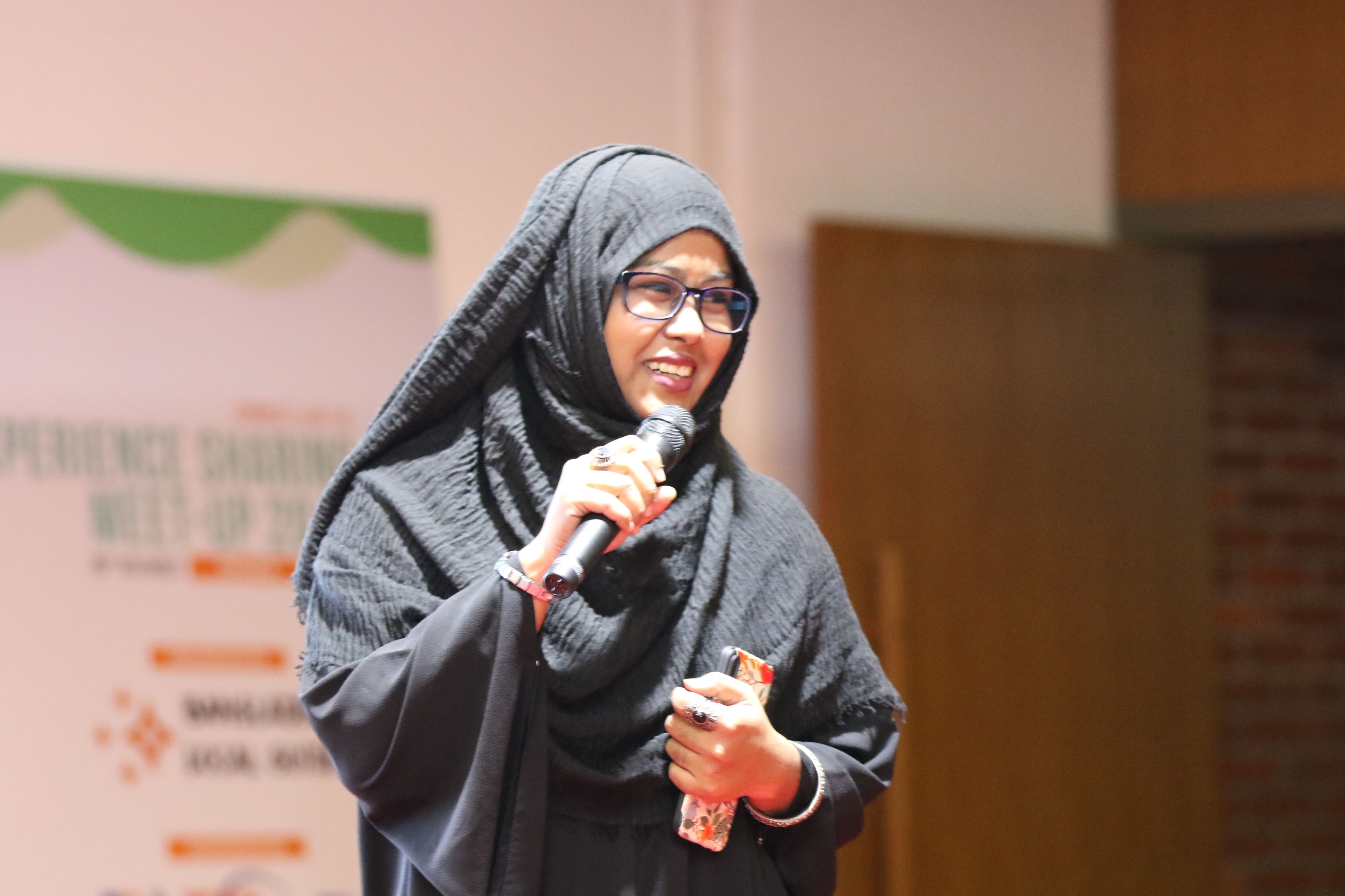 Caption: connect moderator Sumaiya Zafrin on Stage with mic.