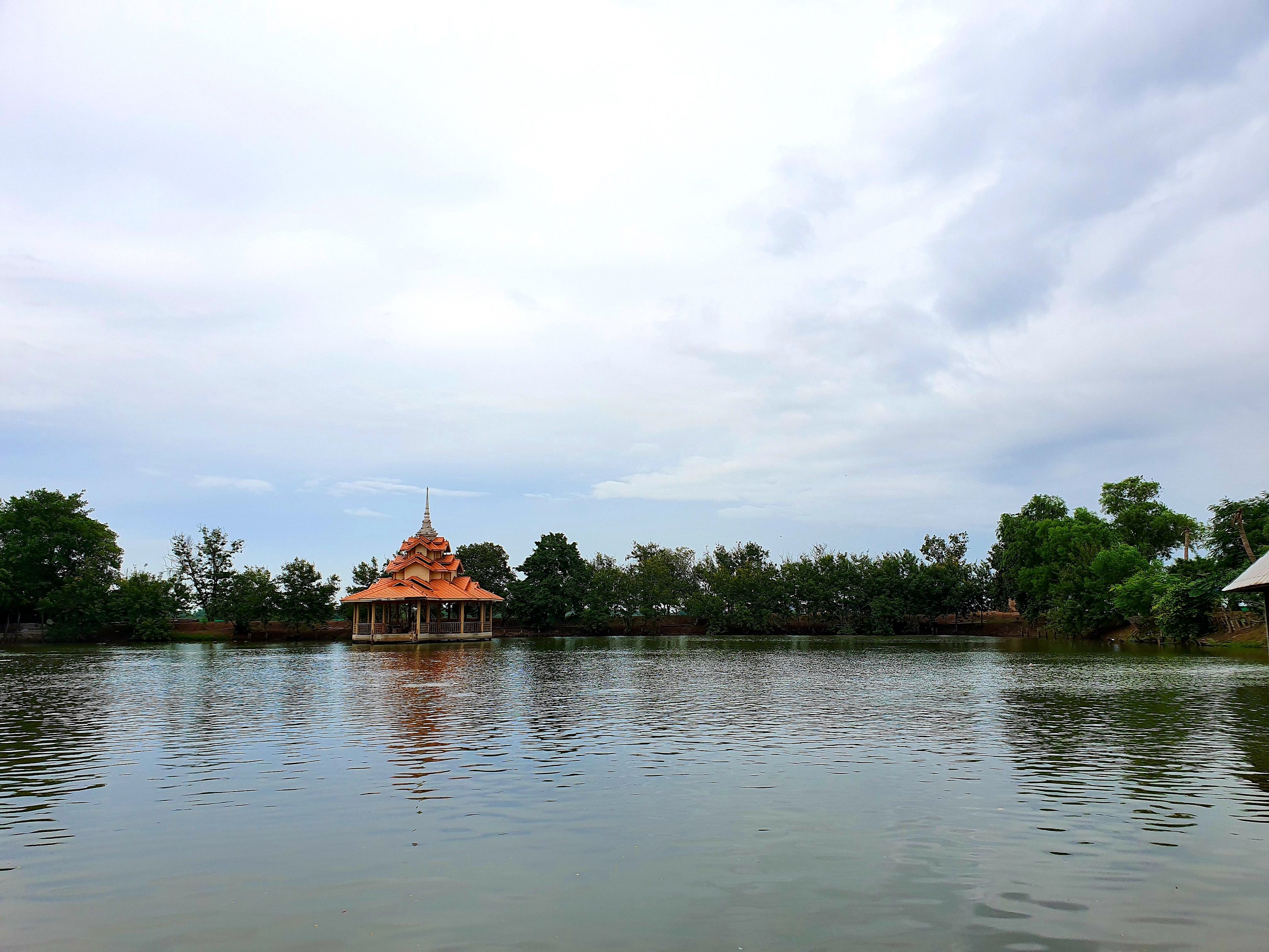 View of a pond and a small pavilion, Wat Chedi Hoi, Pathum Thani, Thailand