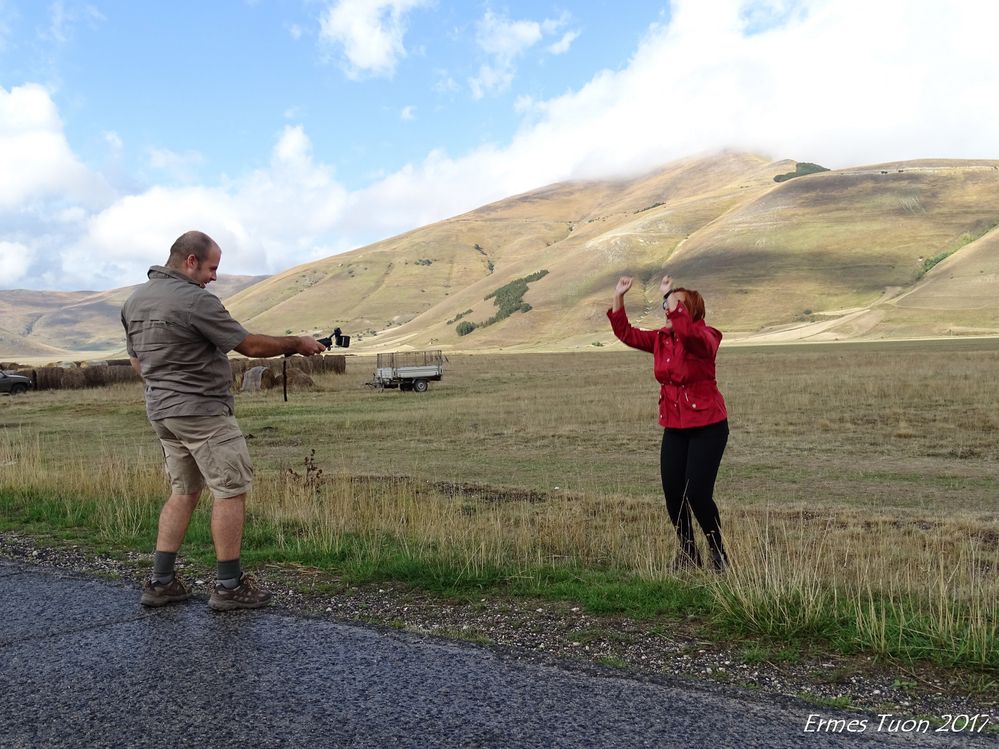 Caption: Local Guides in action during a Meet-up in Castelluccio di Norcia. Emanuele filming Daniela (A jump for Traci) with Bosco Italia in the background