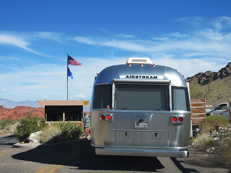 Caption: A photo of the back of an Airstream travel trailer parked at the entrance of Valley of Fire, a state park in Nevada, USA. (Local Guide @NatalkaR)