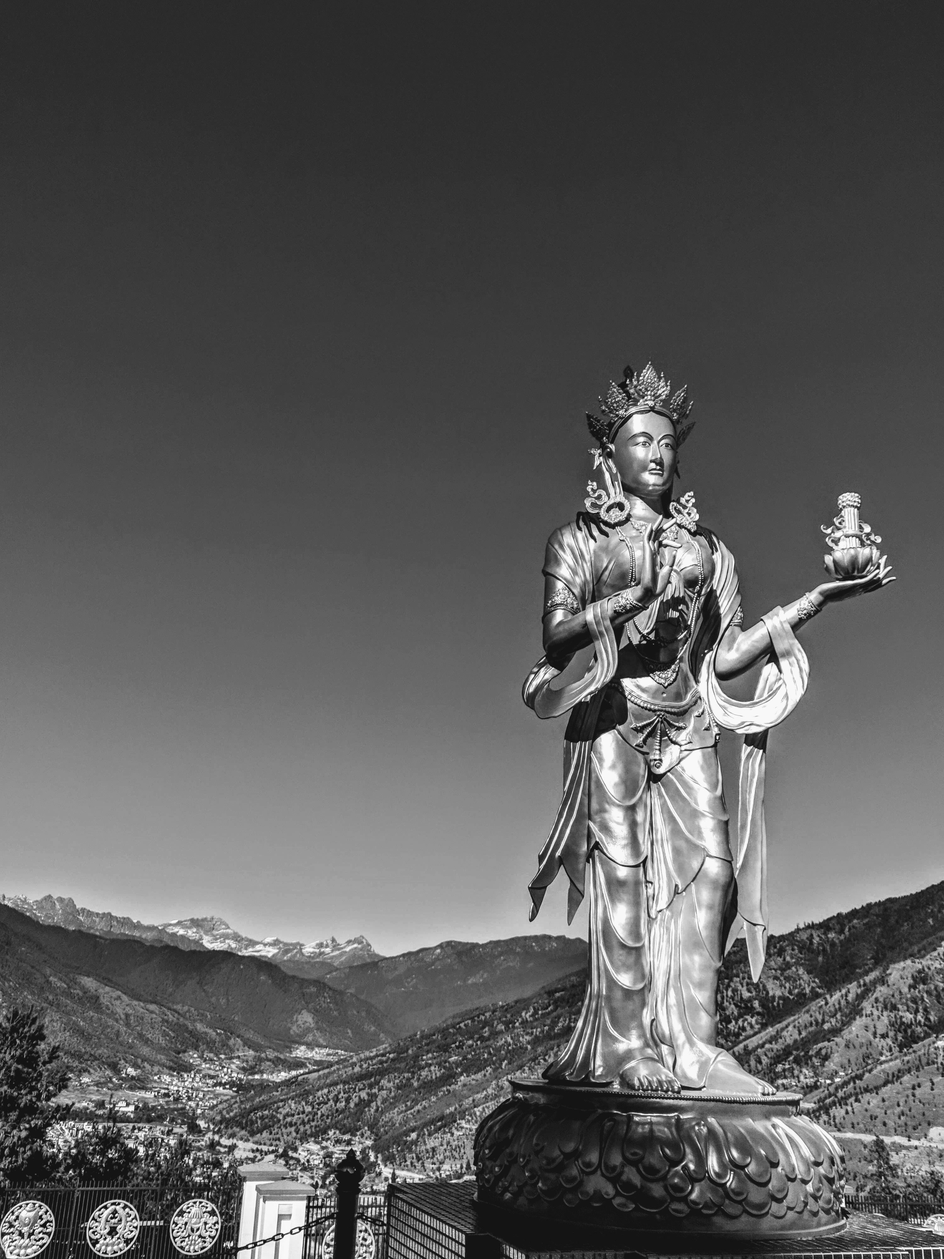 Statue of Bodhisattva standing tall with mountains in the background captured at Buddha's Temple, Thimpu