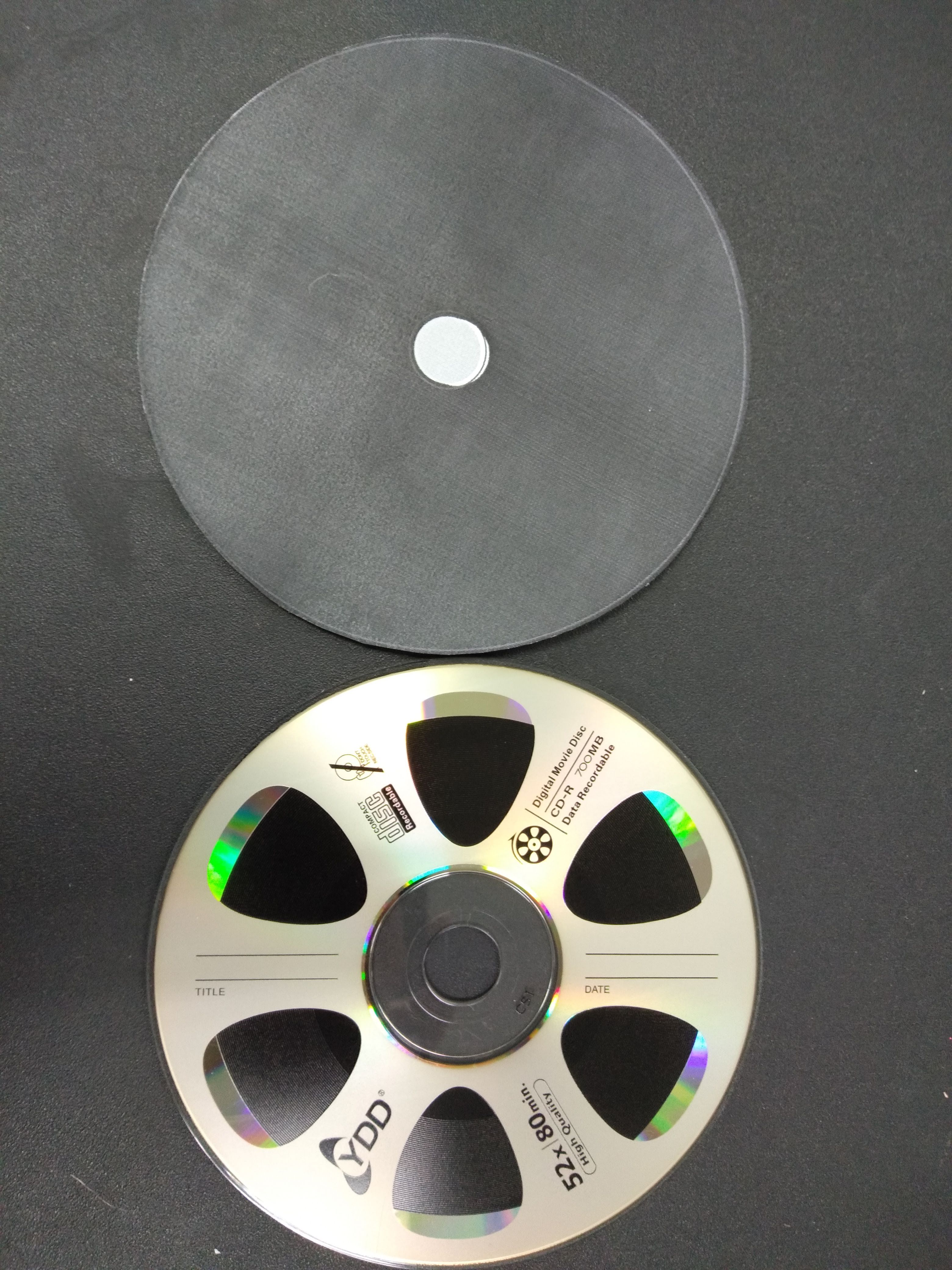A standard size CD with a black printed label
