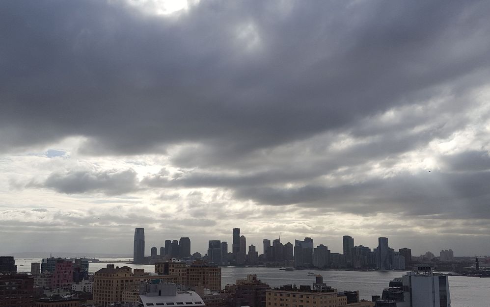 Caption: A photo of the Jersey City, NJ skyline from Manhattan on a cloudy day (Atsuko Takahashi)