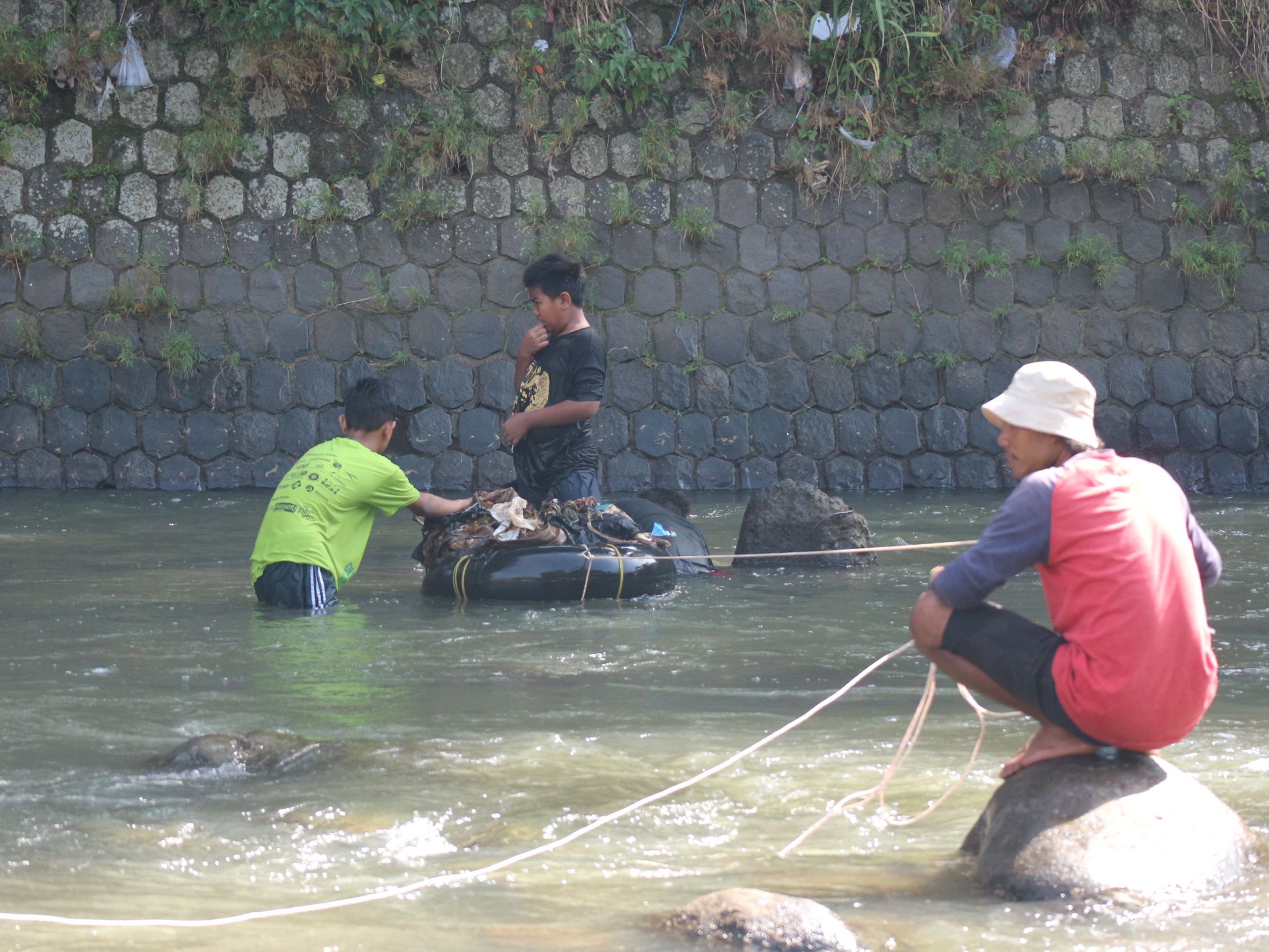 Kegiatan dimulai dengan memulung sampah di Sungai Ciliwung. Tak hanya orang dewasa, anak-anak juga terlibat
