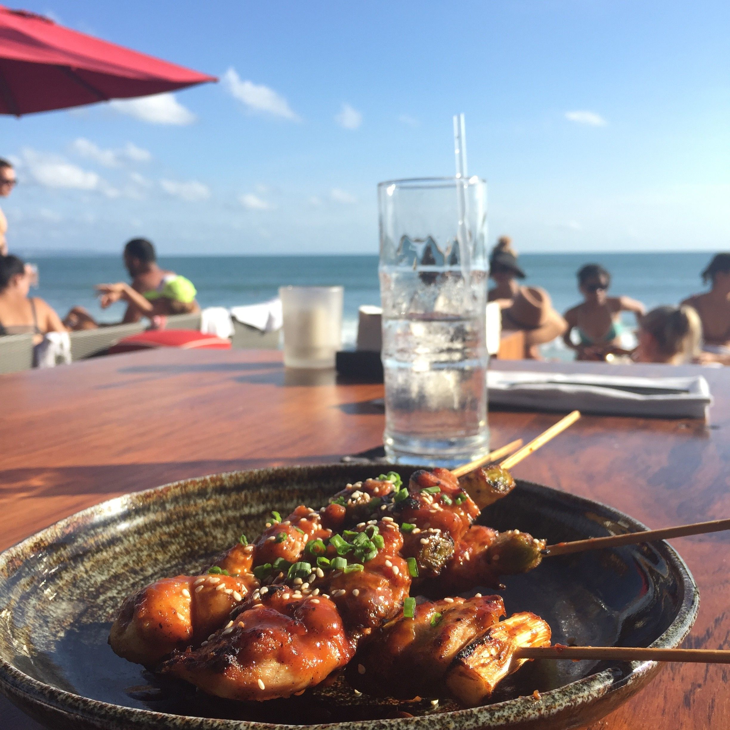 Caption: A photo of glazed chicken satay on a plate with sesame seeds and green onion sprinkled on top. (Local Guide @AngieYC)