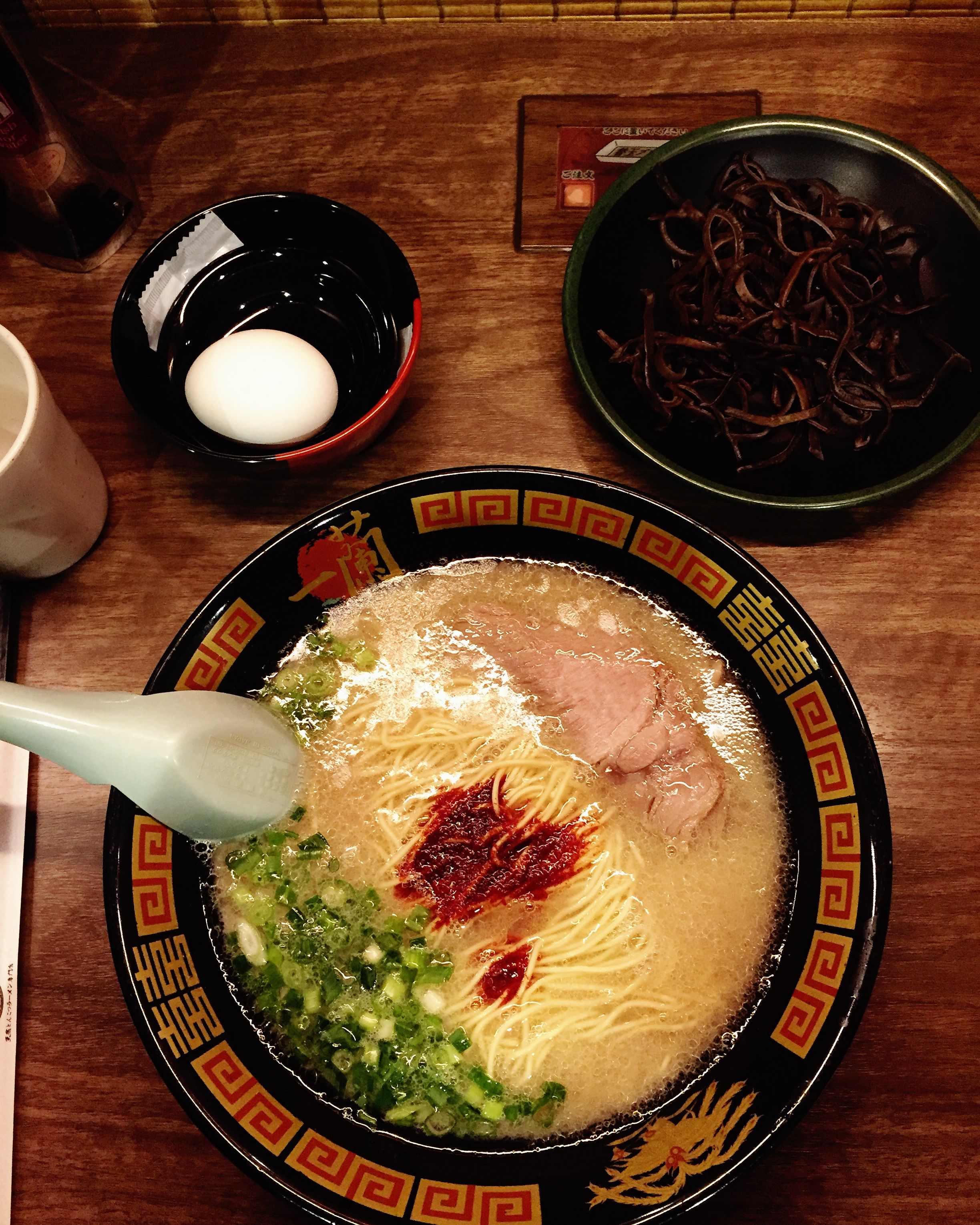 Caption: A picture of a bowl of Tonkotsu ramen - Pork ramen with green onions, seaweed and egg on the other bowl. (Local Guide @ayodo)