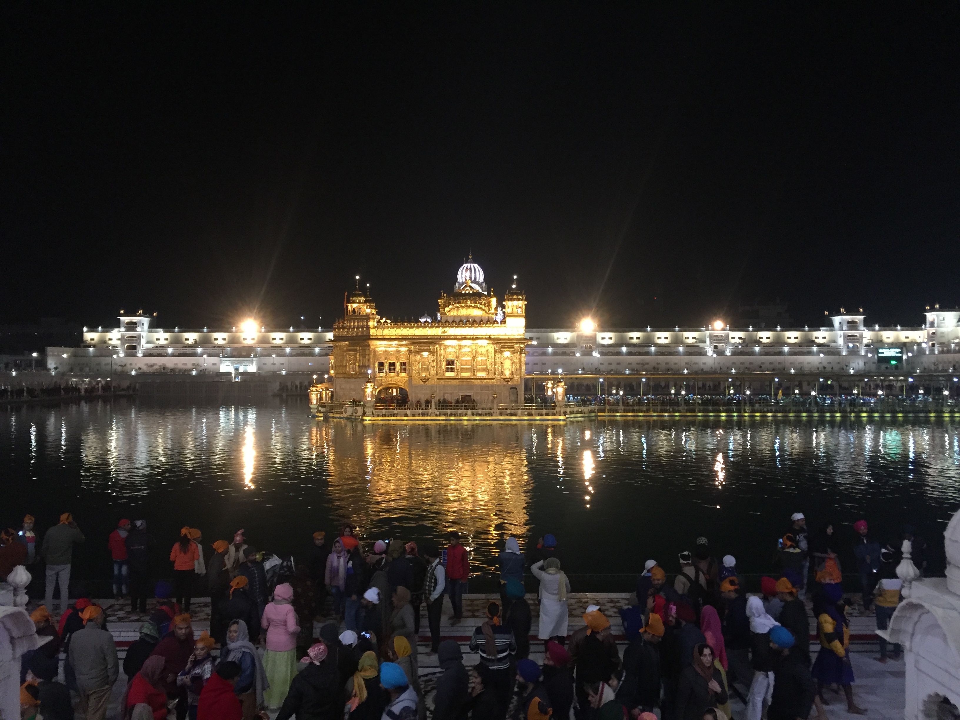 Caption: A photo of the view of the Golden Temple in Amritstar, India captured at night from across the water. (Local Guide @Harmandir Sahib)
