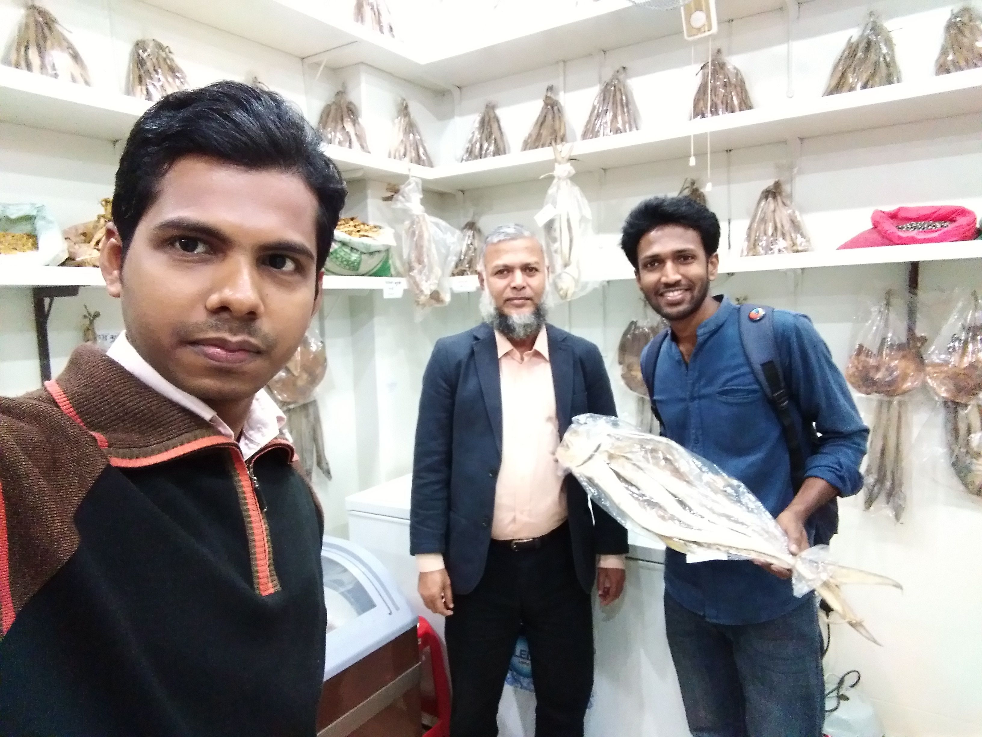 Sadman brother take a big dry sea fish & me. Middle man is shop owner.