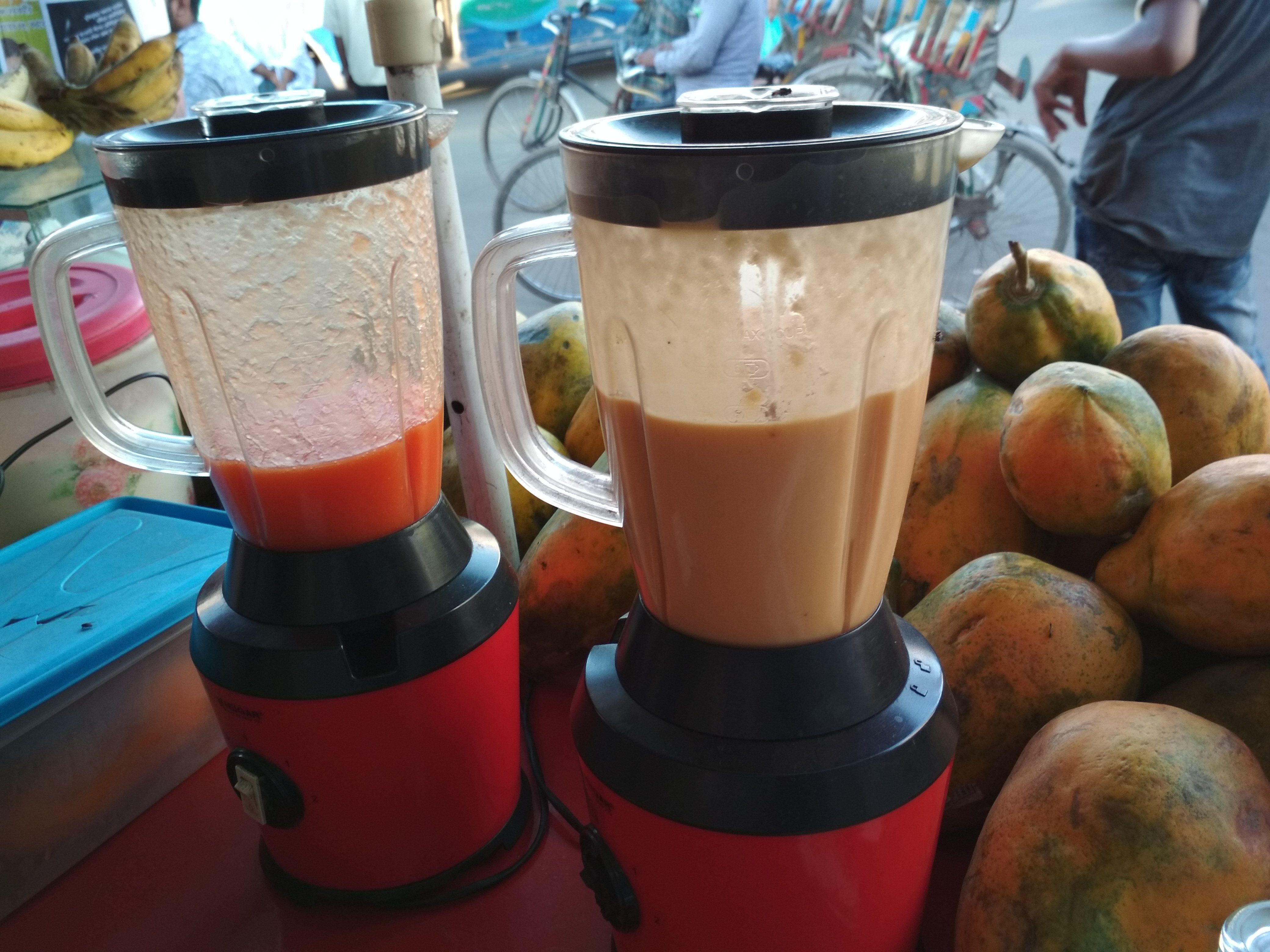 Fruit juices are blended in the jars and waiting fir customers. 1. The red one is a mixture if papya and sugar, 2. The mixed fruit juice. It will make you happy.to drink.