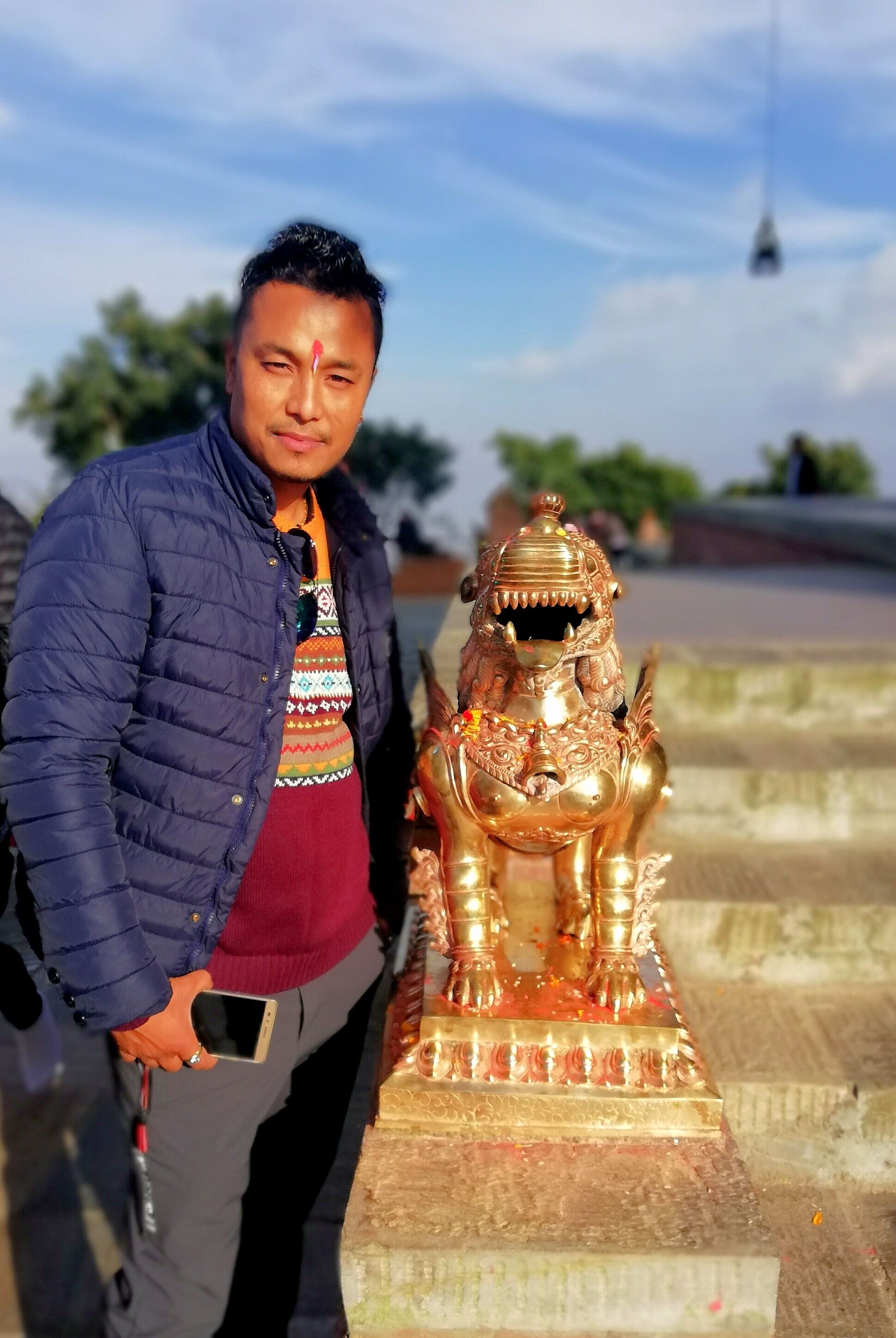A photo of local guide@Mr_Prach with the idol of lion(Syangli) at Chandragiri Hills, Nepal.