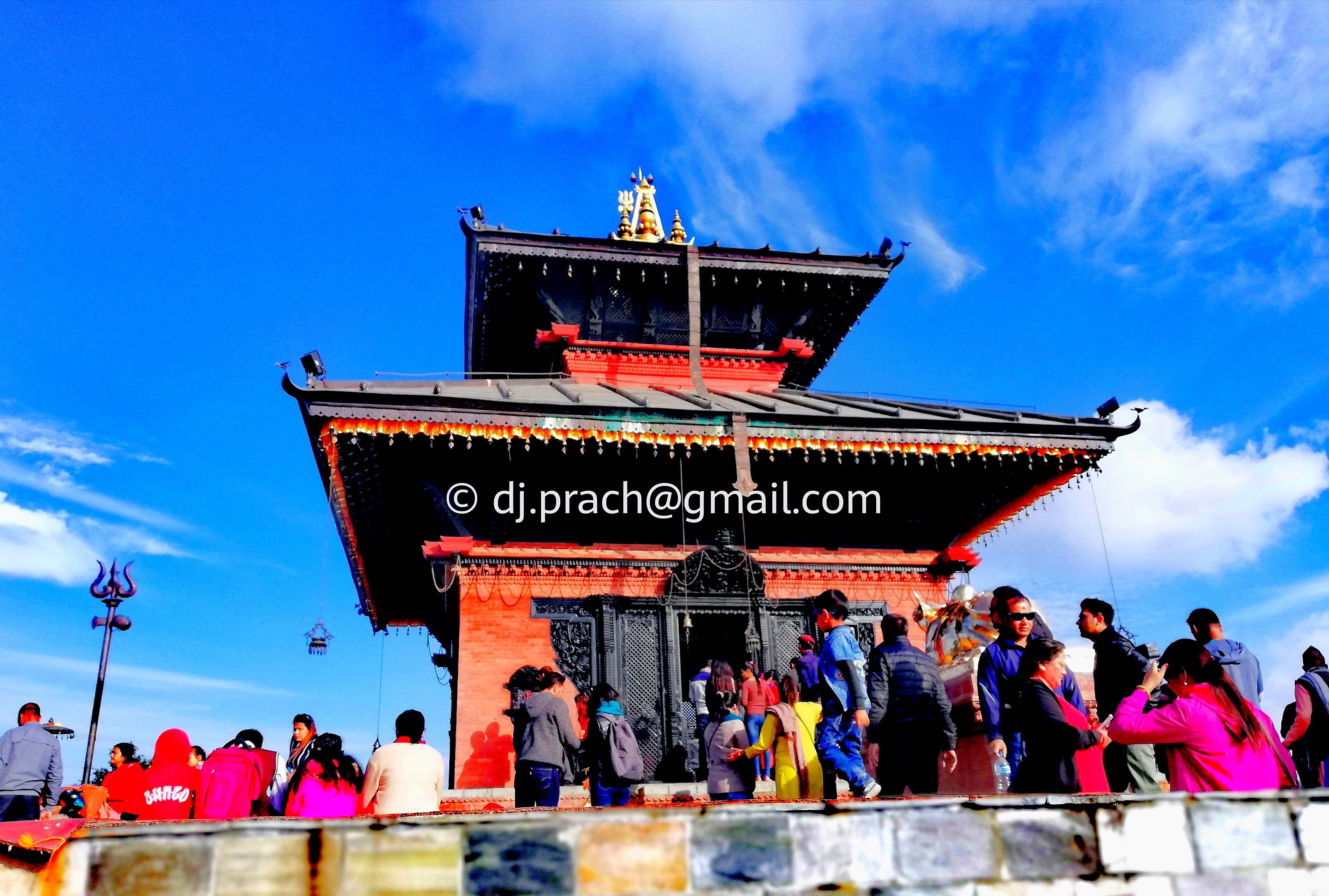 A photo of a Bhaleshwor  Temple with copyright ID and pilgrims visitor at Gonga Chow: Chandragiri Hills, Nepal.