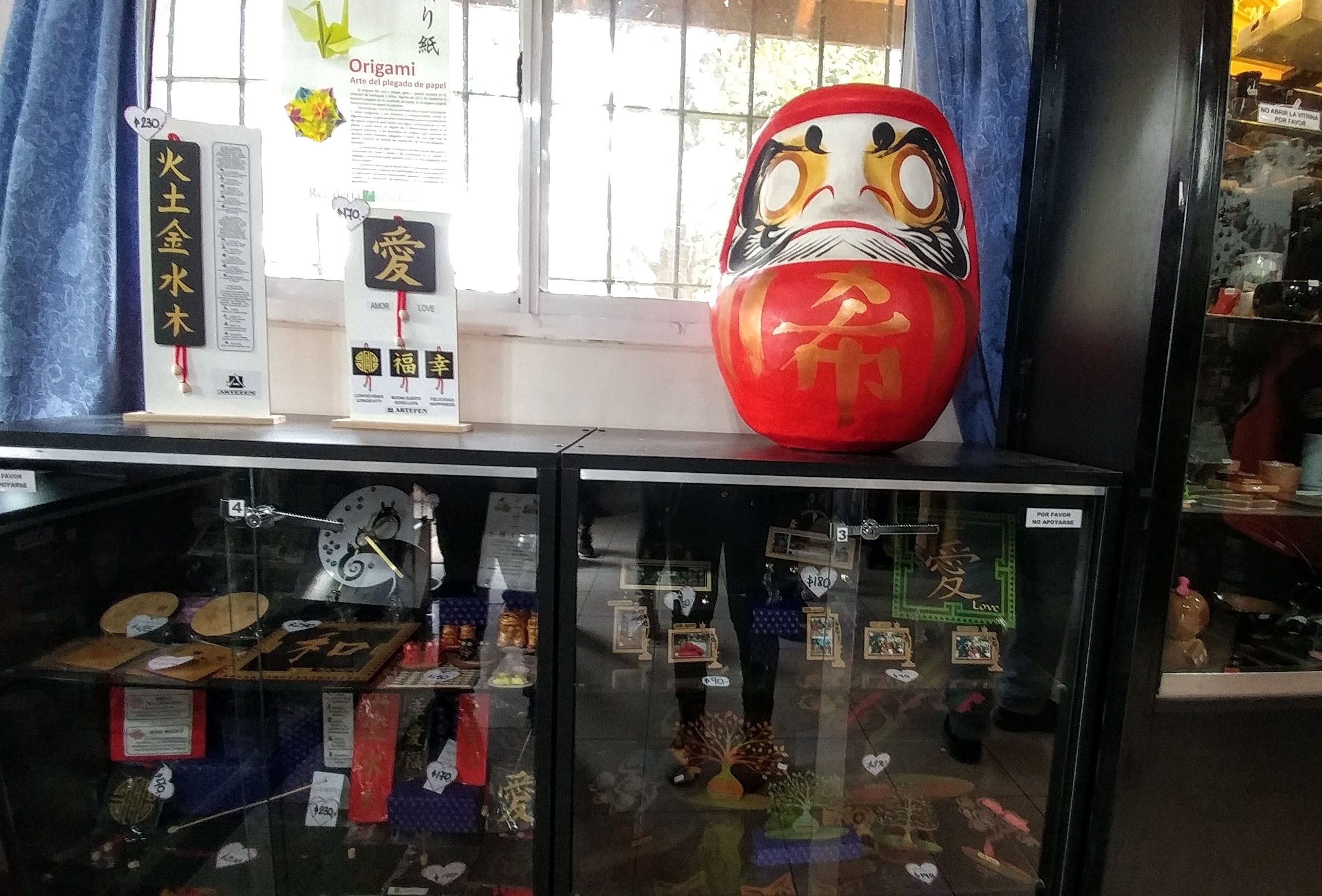 Caption: A photo taken in the inside of the gift shop with a big Daruma.