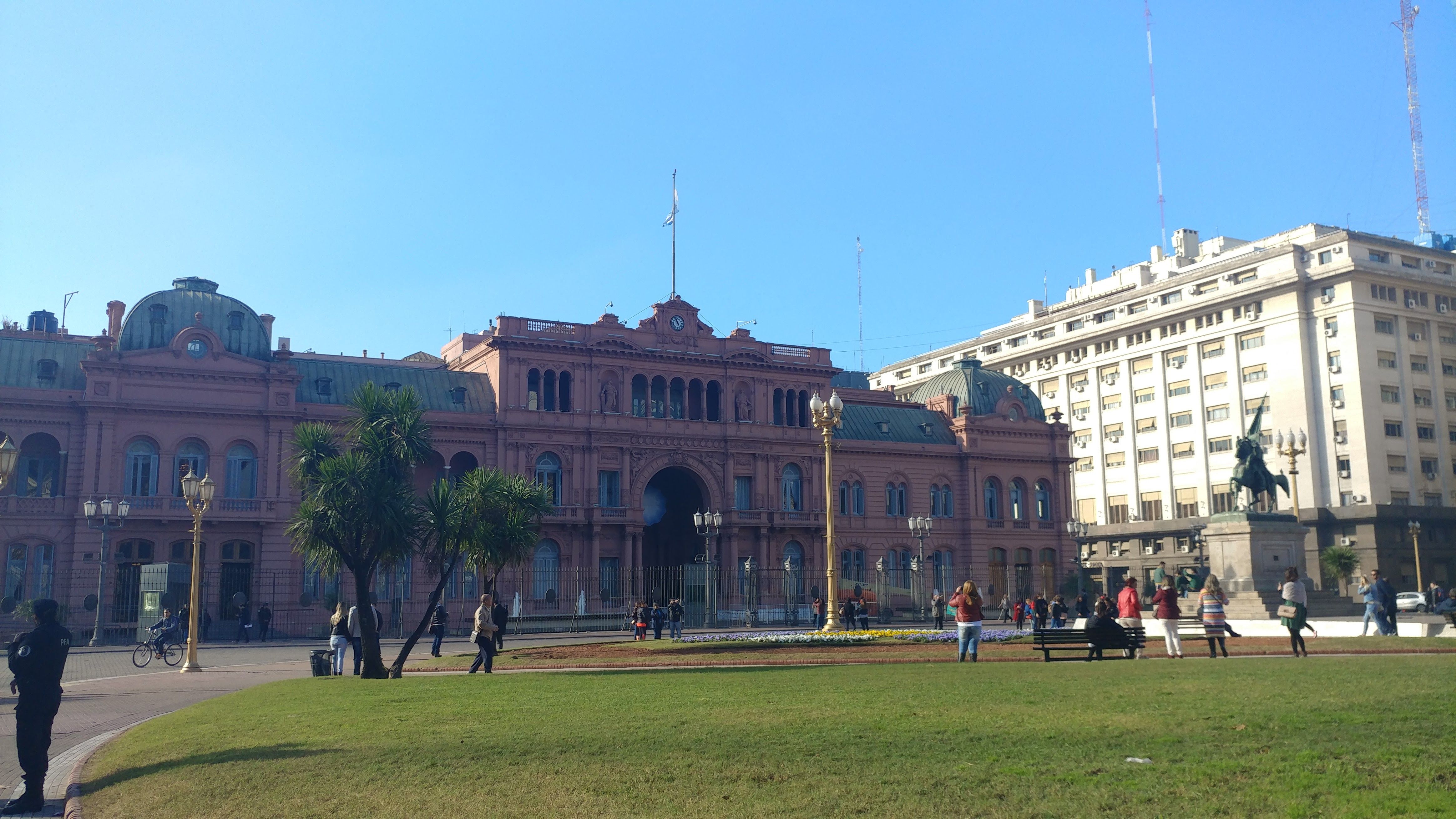 Caption: A photo of  the Casa Rosada building, and the park in front of it.