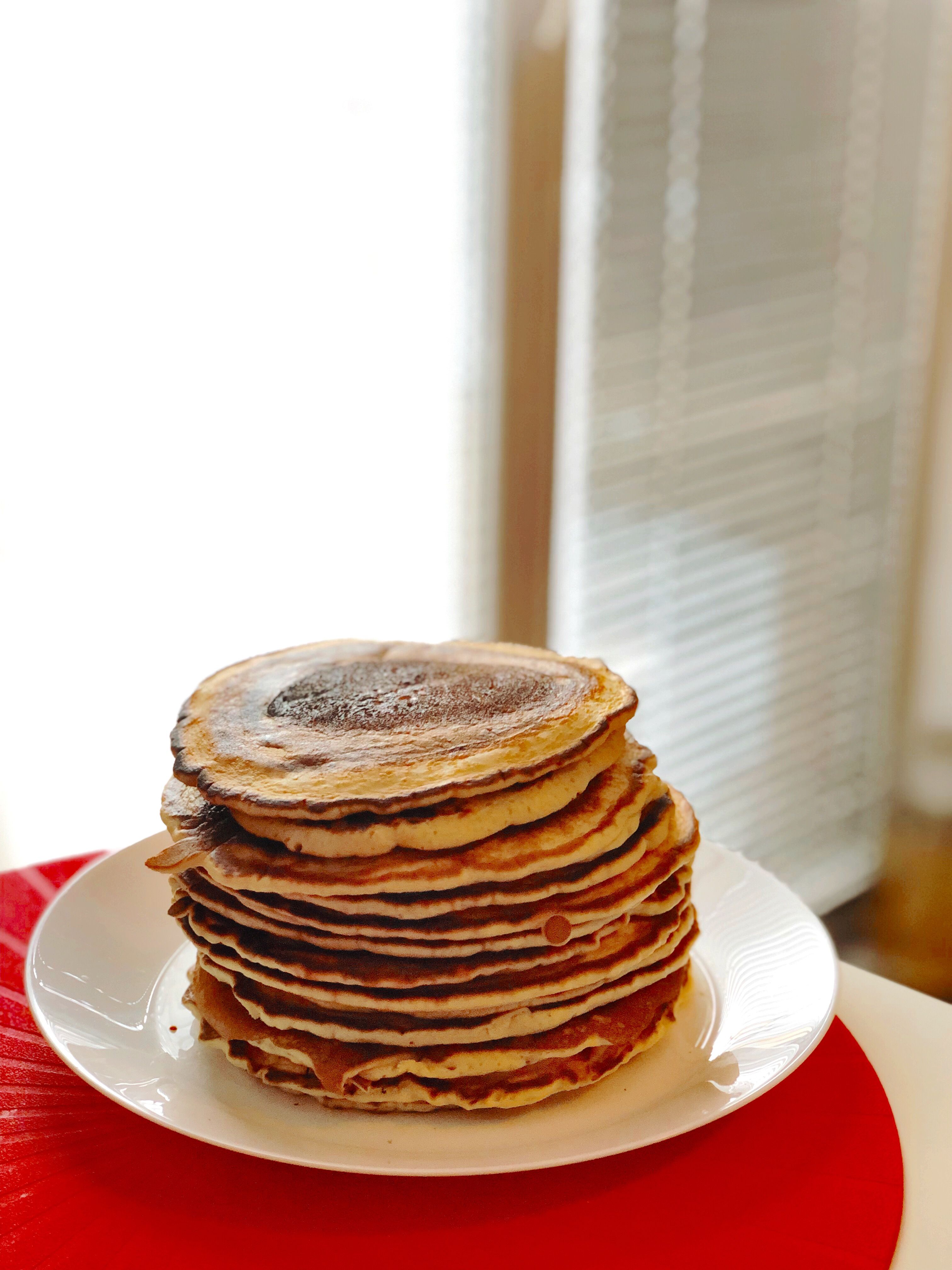 Caption: A photo of American pancakes piled on top of each other  on a plate.