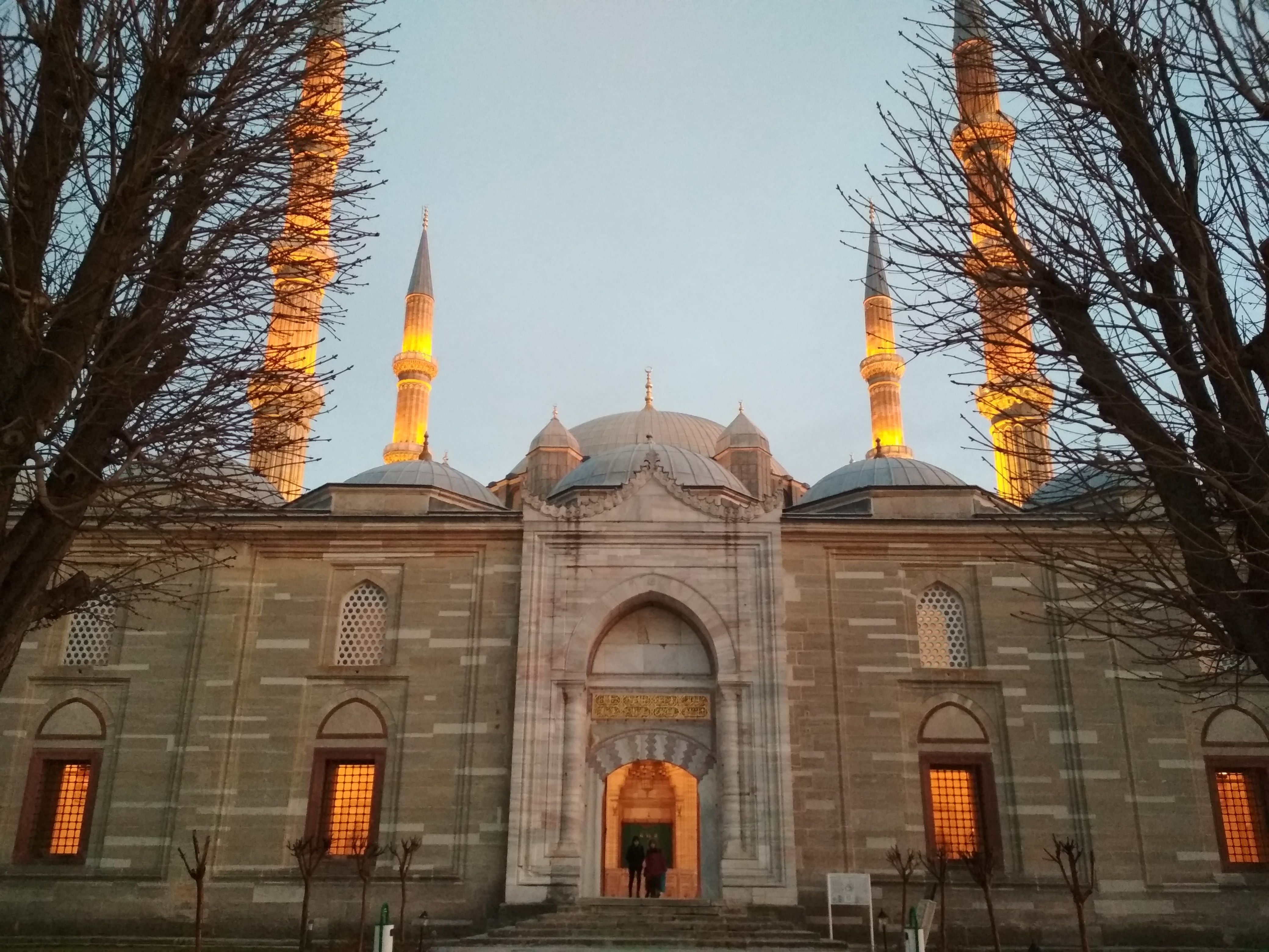 Caption: A photo of the side facade of the Suleymaniye Mosque in Edirne, Turkey, lit up in orange lights at dusk. (Local Guide @DeniGu)
