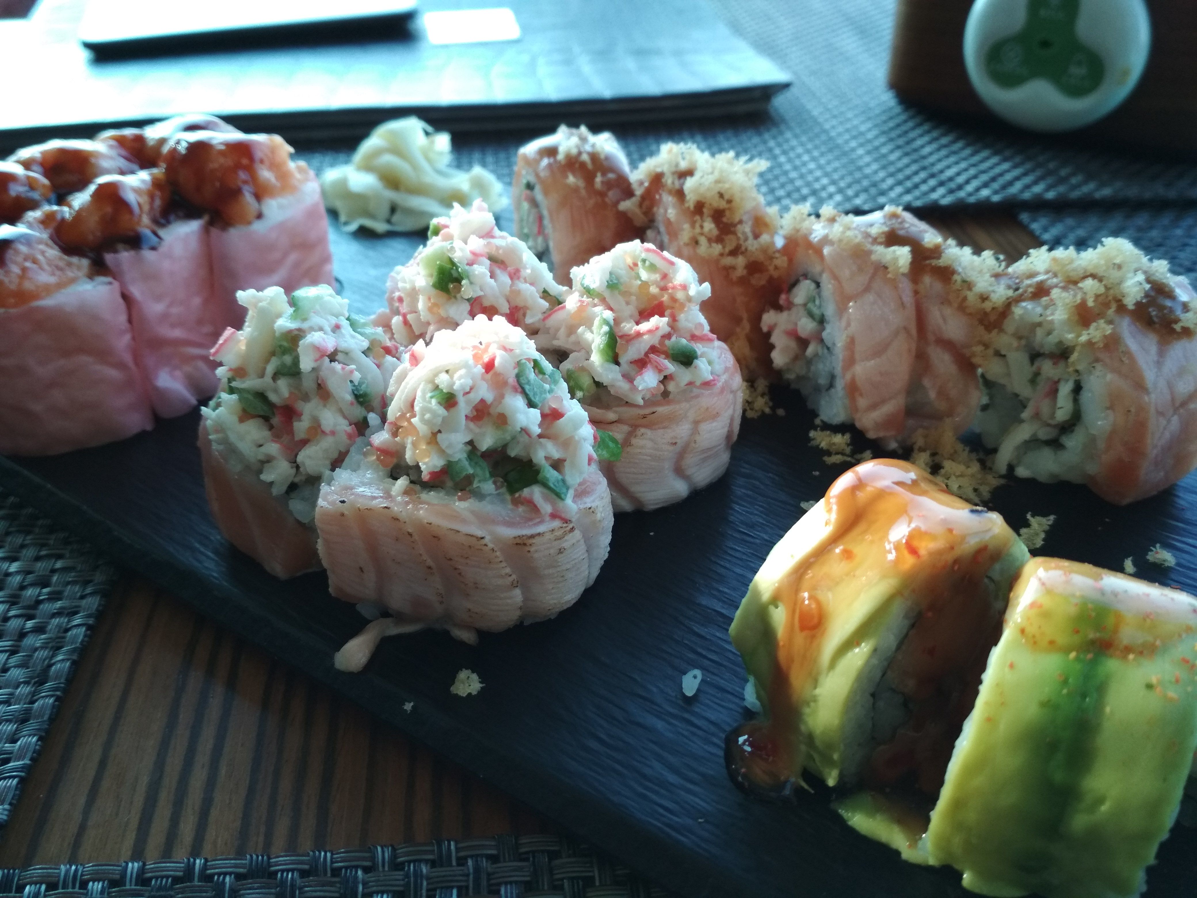 Caption: A close-up photo of a plate with various sushi rolls with salmon, crab meat, avocado, breadcrumbs, and sauces at SASA, Bulgaria. (Local Guide @DeniGu)