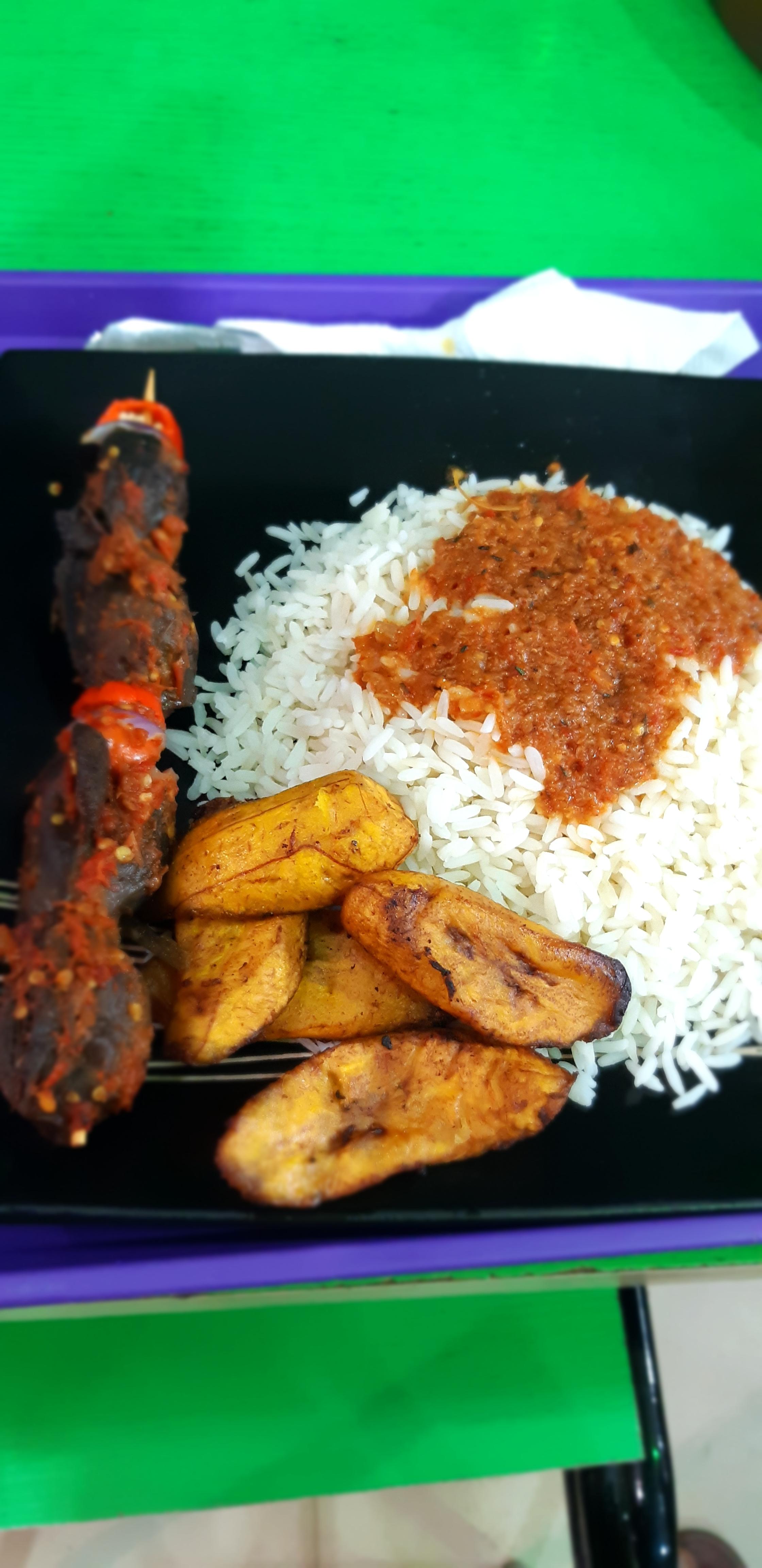 Rice and plantain with spicy skewed gizzad