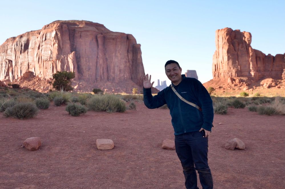 Caption: A photo of Yoshi smiling and waving at Monument Valley, AZ, USA. (Local Guide @Yoshi_Mirai)