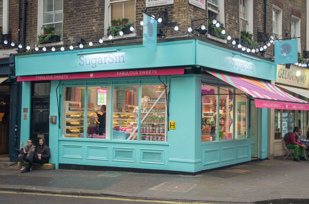 Caption: A photo of the pastel blue storefront of SugarSin, with rows upon rows of candy visible through the glass. (Local Guide Mohamed Ben Osmane)