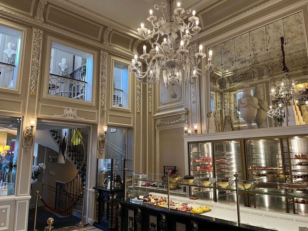 Caption: A photo inside Pâtisserie Méert, showing the high ceiling and ornate chandelier and walls overlooking a display of pastries. (Local Guide Dominique Bellin)