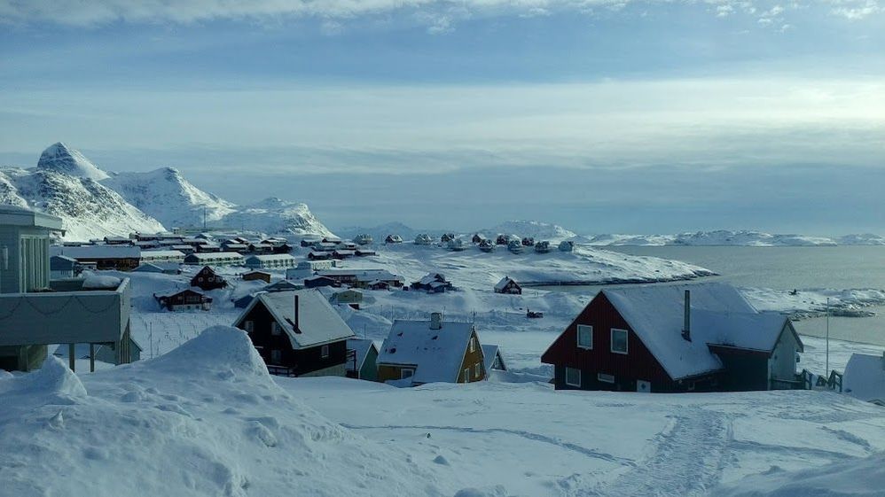 Caption: A photo of low-rising houses and hills covered in snow in Nuuk, Greenland. (Local Guide Jakub Jacques)
