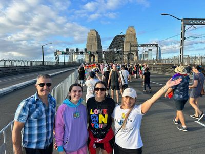 Local Guide Penny Christie and family posing for a photo on the Sydney Harbour Bridge during Sydney World Pride March 2023