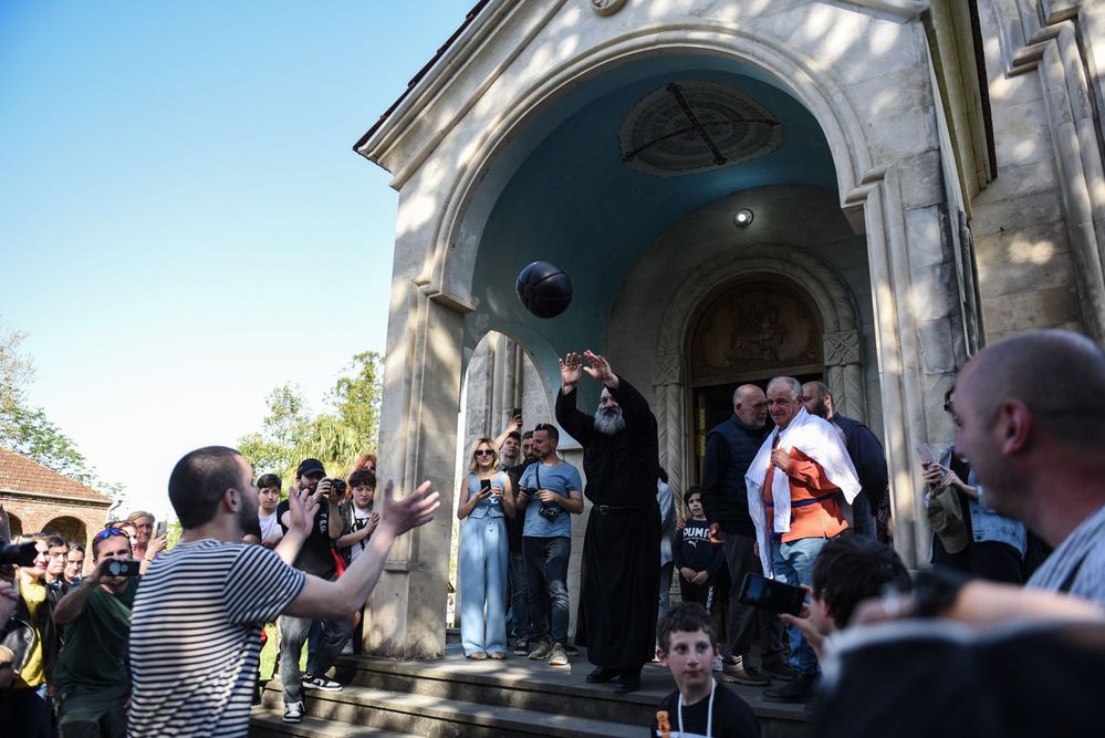 Priest Saba throws the ball outside the church.