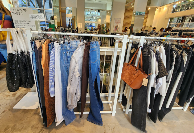 Caption: A rack of various used clothing items for sale.