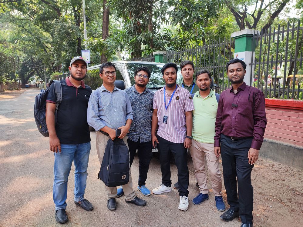 Group photo standing Infront of a car in  front of Nazrul Institute Center, Cumilla