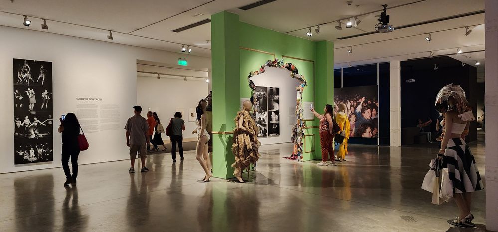 One of the rooms of  the Modern Museum in Buenos Aires, a museum of modern art. In this photo can be seen several persons enjoying the different pieces of art. This room was dedicated to recycling, so most of the art pieces are made with different type of recyclables, even the green arch in the center was fully surrounded by recycled objects.