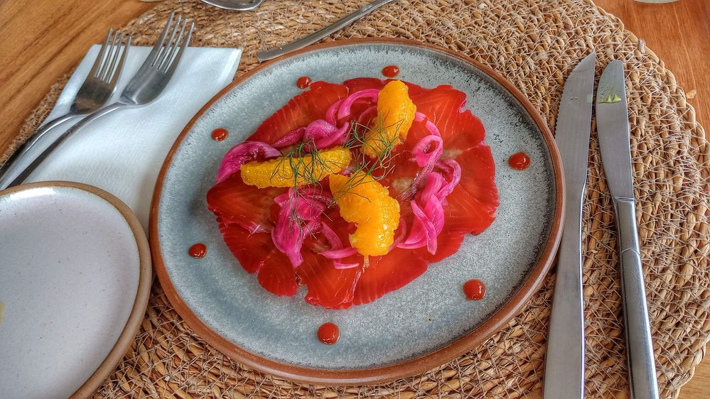 Caption: Carpaccio with orange  segments and  teriyaki sauce