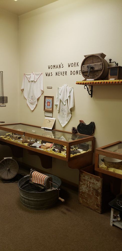Caption: A photo of the Pine-Strawberry Museum showing a display of housework tools from the early 1900s and a quote on the wall saying, ‘Woman’s work was never done.’ (Local Guide @AZ_2021)