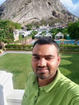 LG Nandkk taking selfie from hotel balcony, background view of a mountain