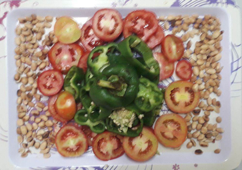 Picture of sliced tomatoes and green bell peper garnished with peanuts